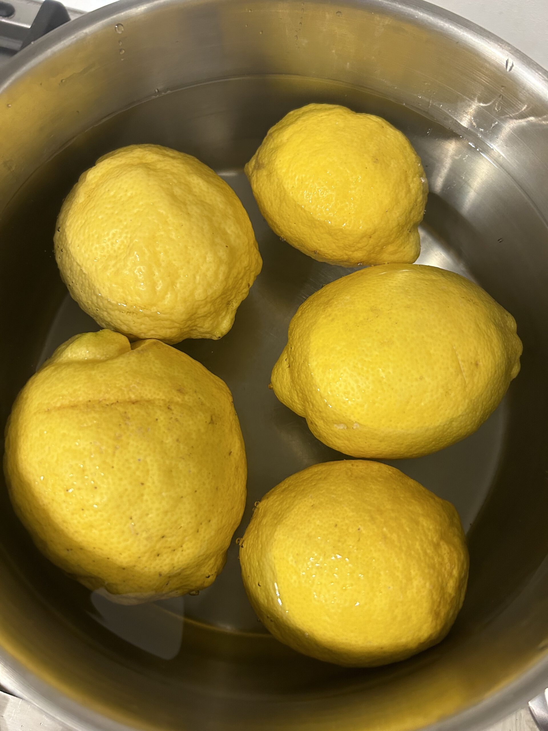 -Wasche die Zitronen gründlich ab und lege sie dann für 24 Stunden mit kaltem Wasser in einen Topf  oder Schüssel. Deckel drauf und eine Portion Geduld dazu.